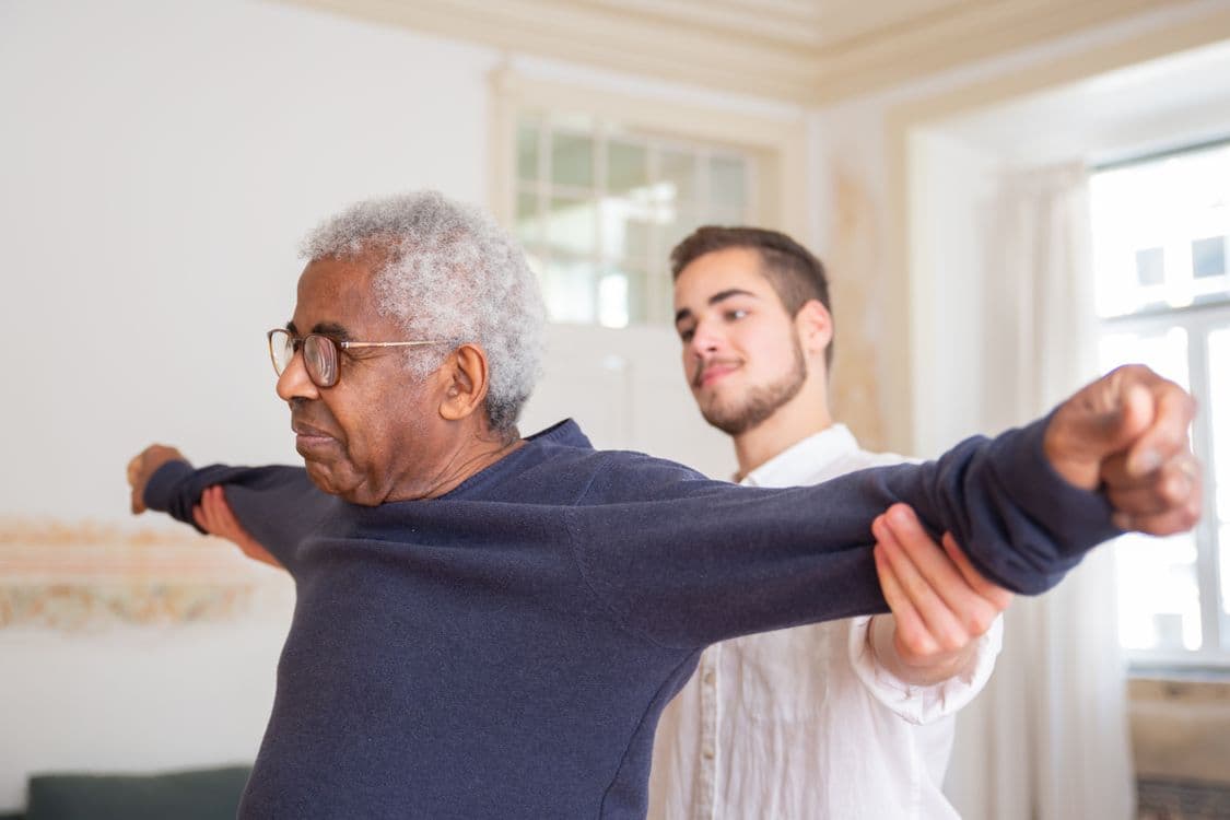 Physical therapist helping patient recover at home